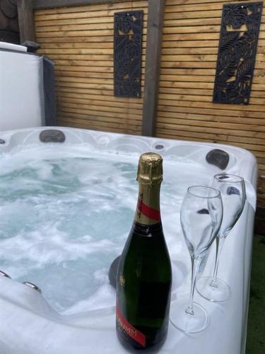 a bottle of champagne and two wine glasses in a hot tub at Go Glamping at Inverness & Loch Ness in Inverness