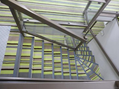 a staircase with metal railings in a building at Hotel ARBOR - Les Hunaudieres - Le Mans Sud - Mulsanne in Mulsanne