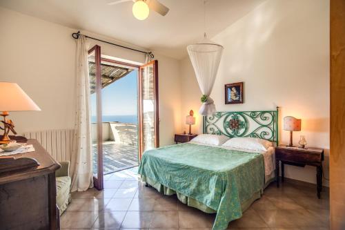 a bedroom with a bed and a sliding glass door at GOCCE VILLAS - Sunshine Villa in Massa Lubrense