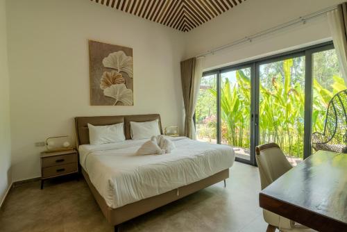 a bedroom with a bed and a large window at Villa Kiri in Ko Phangan