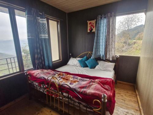 a bedroom with a bed in a room with windows at Wild Way Resort in Kanatal