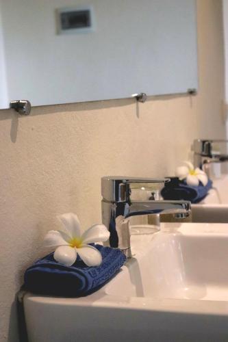 a bathroom with two sinks with a towel with a flower on it at Komba on the Rocks in Nosy Komba