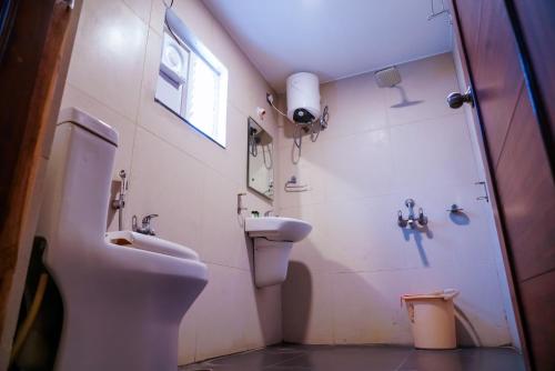 a bathroom with a sink and a toilet and a shower at Tree Inn Jubilee in Hyderabad