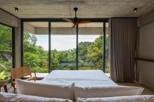 a bedroom with a bed and a large window at Palm Stone Villa in Haad Pleayleam