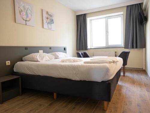 a bedroom with a large bed and a window at Hotel Bentley in Brussels
