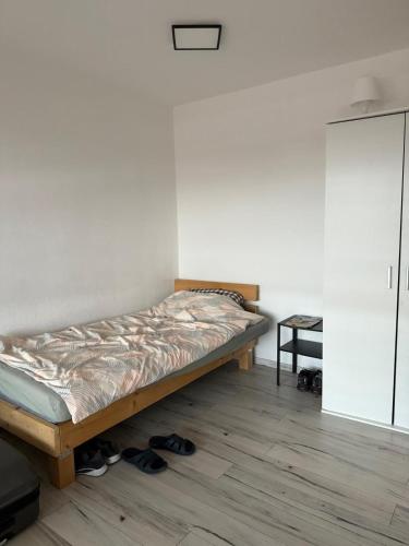 a bed in a room with shoes on the floor at Monteurwohnung und Ferienwohnung Philippsburg in Philippsburg
