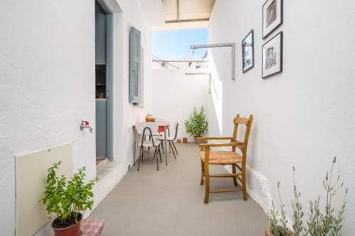 a small apartment with white walls and chairs and a table at Dafni Local Style, 1 Min from Main Beach in Kardamaina
