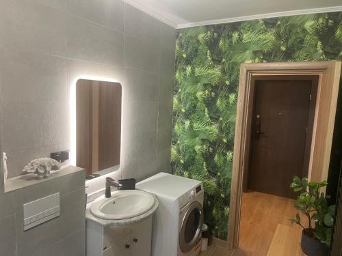 a bathroom with a washing machine and a sink at Bella in Târgu-Mureş