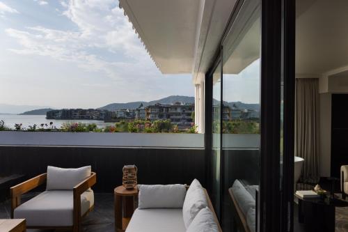 a room with a balcony with a view of the water at Arcadia Small courtyard in Dali Shuanglang