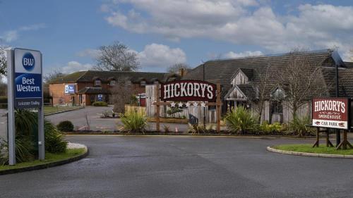 a house with signs on the side of a street at Best Western Leicester Oadby in Great Glen