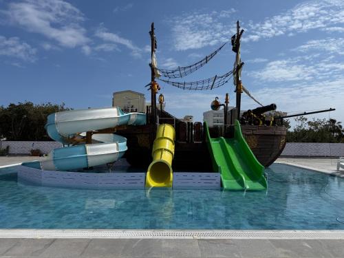 a water slide in a pool with a pirate ship at Papouis Protaras Hotel in Protaras