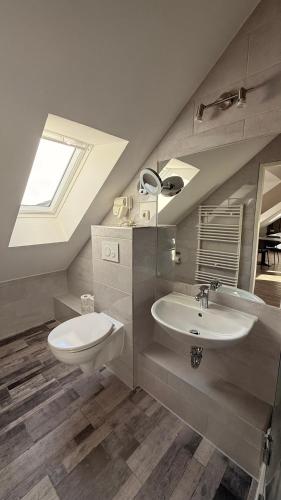 a bathroom with a sink and a toilet and a window at Casino Hotel Hamm in Hamm