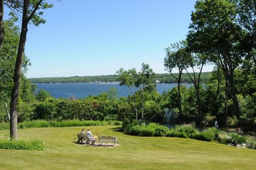 duas pessoas sentadas num banco de parque perto de um lago em Country House Resort em Sister Bay