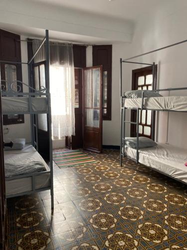 a room with two bunk beds and a tile floor at Hostel le Rhumel in Constantine