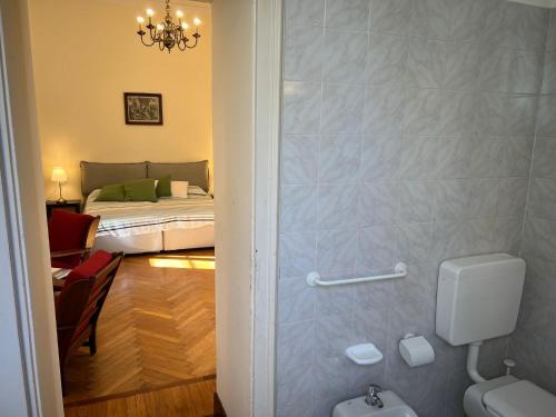 a bathroom with a toilet and a bed in a room at Emy charming apartment with pool in Verbania