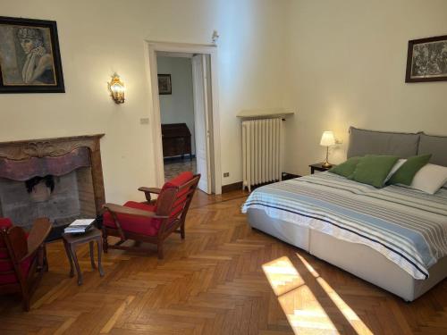 a bedroom with a bed and two chairs and a fireplace at Emy charming apartment with pool in Verbania