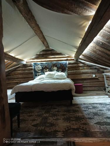 a bedroom with a bed in a room with wooden walls at Drängstugan Bärsta 5 in Kolbäck