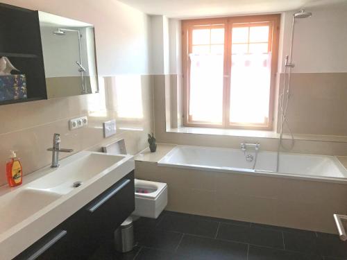 a bathroom with a tub and a toilet and a sink at Ferienwohnungen Haus Castello App9 in Aschau im Chiemgau