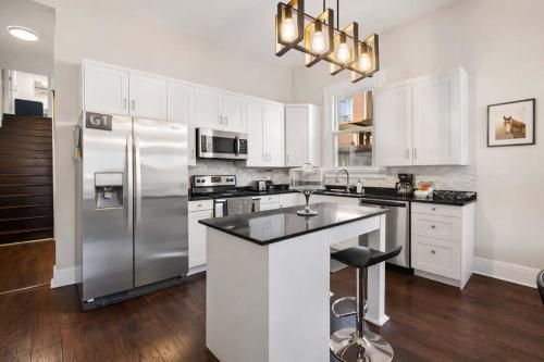 a kitchen with white cabinets and a stainless steel refrigerator at Derby & Bourbon Trail Homebase W Private Backyard in Louisville