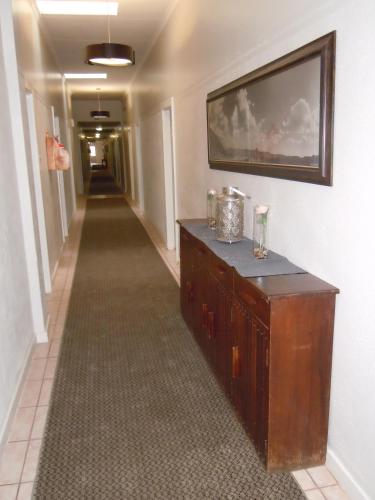 a hallway with a long corridor with a television on a wall at Colesberg Lodge in Colesberg
