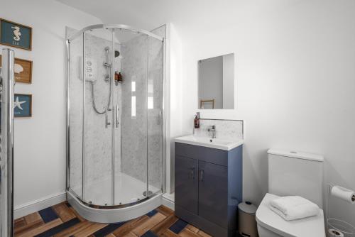 a bathroom with a shower and a sink and a toilet at 6 BR 3 Bath Spacious Tudor House & Free Parking in Powick