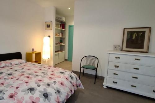a bedroom with a bed and a dresser and a chair at Appartamento Caffaro Vacanza in Ponte Caffaro