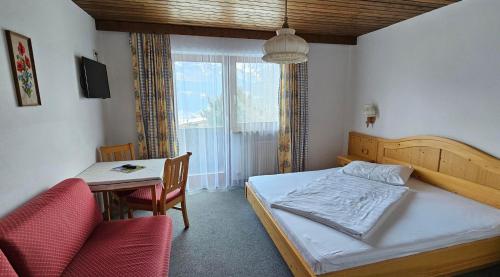 a bedroom with a bed and a table and chairs at Frühstückspension Schönblick in Ellmau