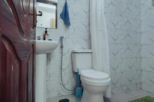 a bathroom with a white toilet and a sink at Work Friendly Studio near Nairobi CBD and Westlands in Nairobi