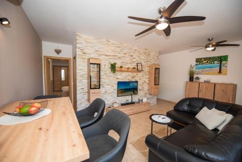 a living room with a wooden table and leather furniture at Laurentina - Modern Apartment with Large Terrace near Beach-quiet and comfortable in Sutivan