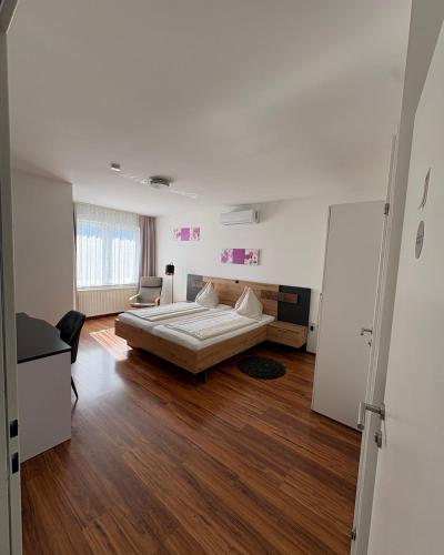 a bedroom with a bed and a chair in it at Pension Fürstenhof in Villach