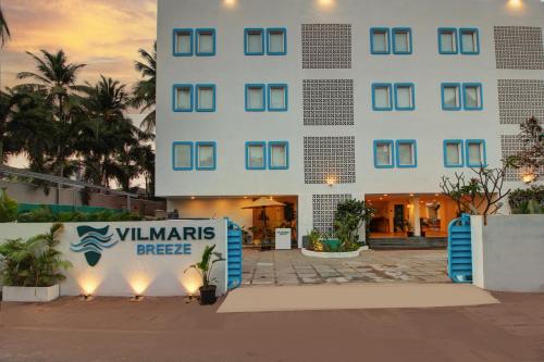a large white building with a sign in front of it at Hotel Vilmaris Breeze in Calangute