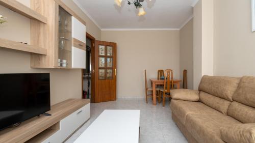 a living room with a couch and a television at Langosteira Beach, spacious apartment in Fisterra
