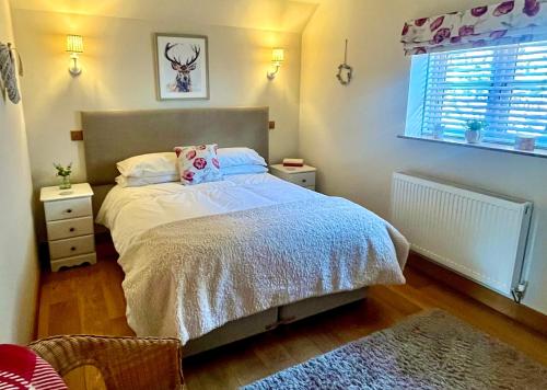 a bedroom with a bed and a window at Cosy Cottage for Two in the Peak District with Parking in Onecote