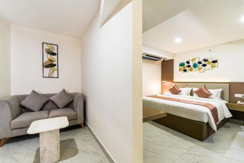 a bedroom with a bed and a couch at Hotel Star Place in Chennai