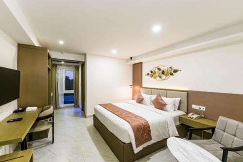 a hotel room with a bed and a desk at Hotel Star Place in Chennai