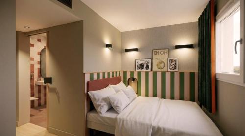 a bedroom with a bed with white sheets and a window at Hôtel EH OH Orly Rungis in Rungis