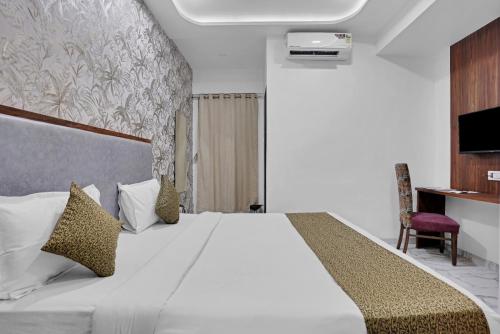 a bedroom with a large white bed and a chair at Hotel New Star in Navi Mumbai
