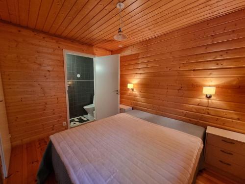 a bedroom with a bed in a wooden wall at Tikankolo in Puumala