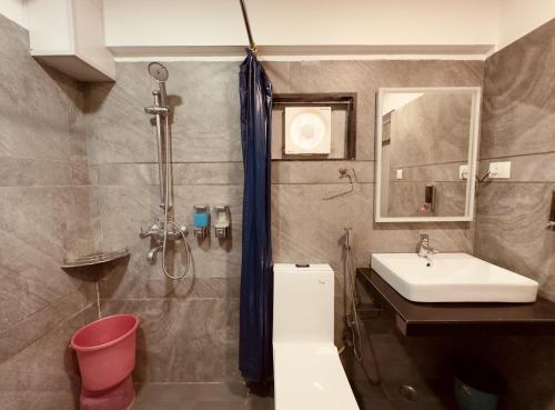 a bathroom with a sink and a shower at Hotel Marigold Mount Abu - With Swimming Pool in Mount Ābu