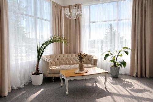 a living room with a couch and two potted plants at Penzión Lapáš u Hoffera in Nitra