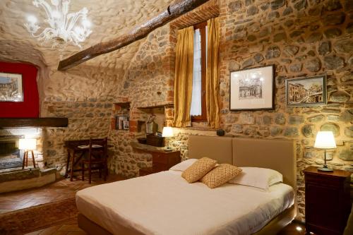 a bedroom with a bed and a stone wall at Locanda Osteria Marascia in Calolziocorte