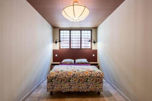 a bedroom with a bed and a window at Le Magasin à Poudre in Rocroi