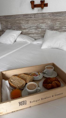 a box of bread and pastries on a bed at Portal De La Rioja in Haro