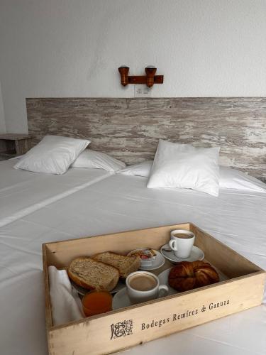 a box of bread and pastries on a bed at Portal De La Rioja in Haro