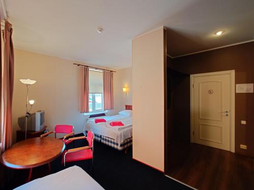 a hotel room with a bed and a table at Otrā Elpa in Valka
