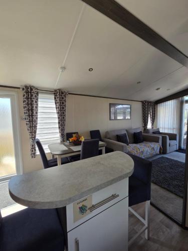 a kitchen and living room with a couch and a table at Rody's Cosy Corner in Crowle
