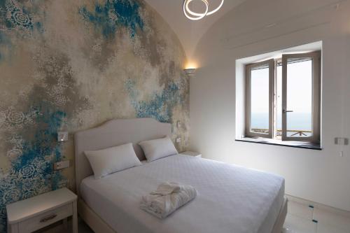 a bedroom with a white bed and a window at Borgo Sant'Anna in Amalfi