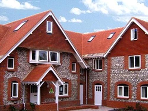 a large brick house with a red roof at Stonehenge Farmhouse in Salisbury