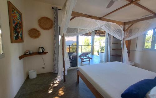 a bedroom with a bed and a balcony at Komba on the Rocks in Nosy Komba