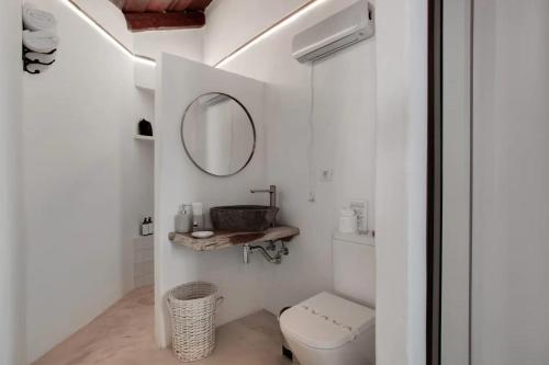a bathroom with a toilet and a mirror at La Paredita Casa Guimar in Tanque